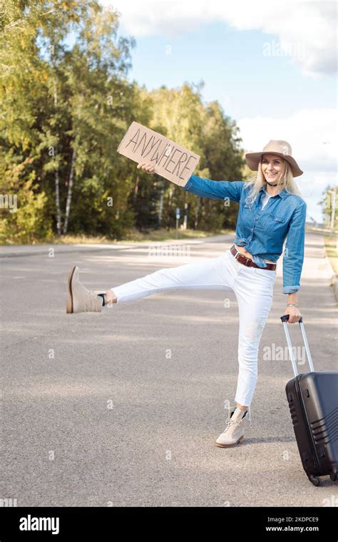Vertical Begging Funny Smiling Blond Woman Autostop Hitchhiking By Raised Leg Sign With Plate