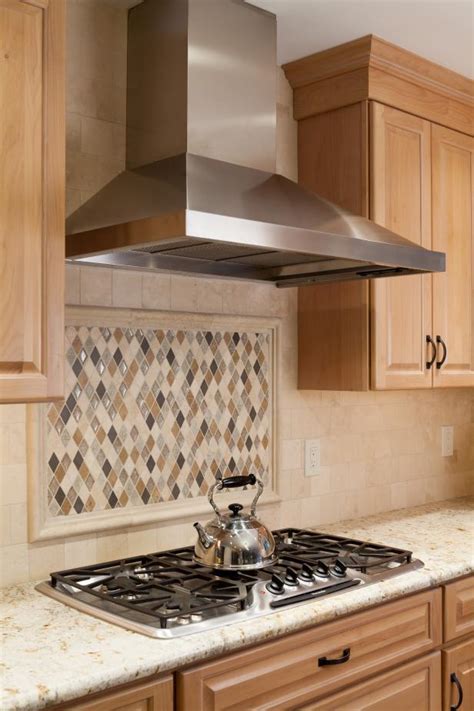 Geometric cooktop backsplash tiles in gray and white bring attention in a subtle, stylish and appealing way. Kitchen with Diamond-shaped Tile Backsplash and Stainless ...