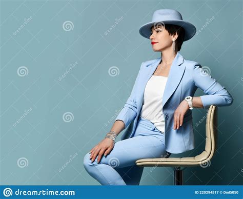 Attractive Smiling Short Haired Brunette Woman In Blue Business Smart Casual Suit And Hat