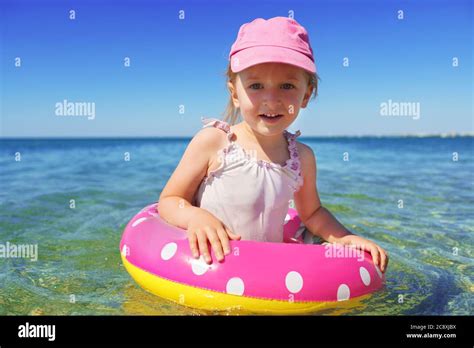 Little Girl In Bikini Swimming In Sea With Swimming Circle Stock Photo