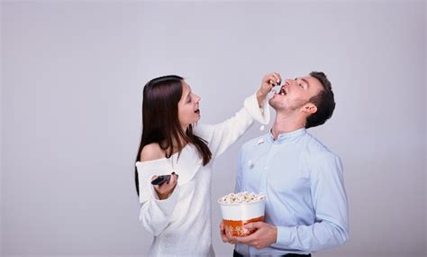 bela jovem casal apaixonado assistindo filme e comendo pipoca foto premium