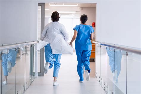 Nurse And Doctor Running In Hospital Corridor Photo From Pikwizard