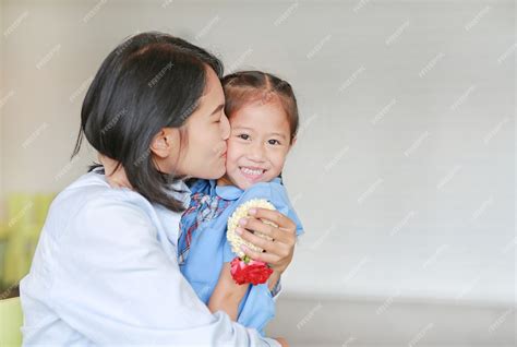 Retrato De Mamá Asiática Besando Y Abrazando A Su Hija En El Día De La