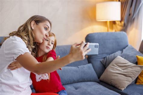 Mother And Daughter Having Fun Taking Selfies At Home Stock Image