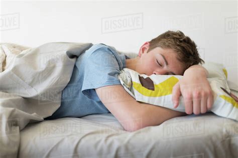 Teenage Boy 16 17 Sleeping In Bed Stock Photo Dissolve