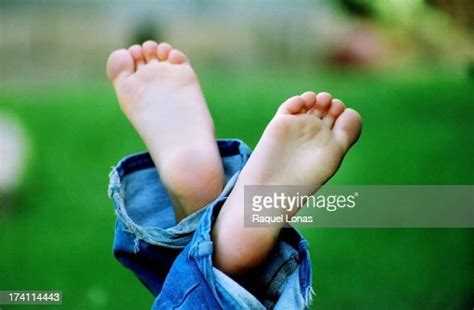 Two Bare Feet In The Air With Blue Jeans Photo Getty Images