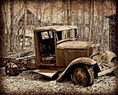 An Old Rusted Out Truck Sitting In The Woods