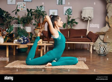 Sporty Woman Doing Yoga Exercise One Legged King Pigeon Pose At Home