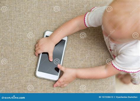 Baby Picks Up A Smartphone From The Sofa Stock Image Image Of
