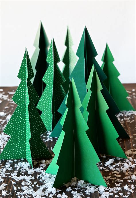 Three Paper Christmas Trees Sitting On Top Of A Table