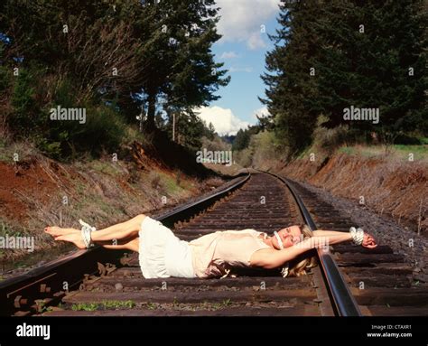A Woman Tied On Some Railroad Tracks Like A Damsel In Distress Stock