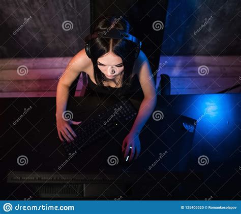 A Woman Looks At Camera While Sitting In Front Of Her Pc And Playing