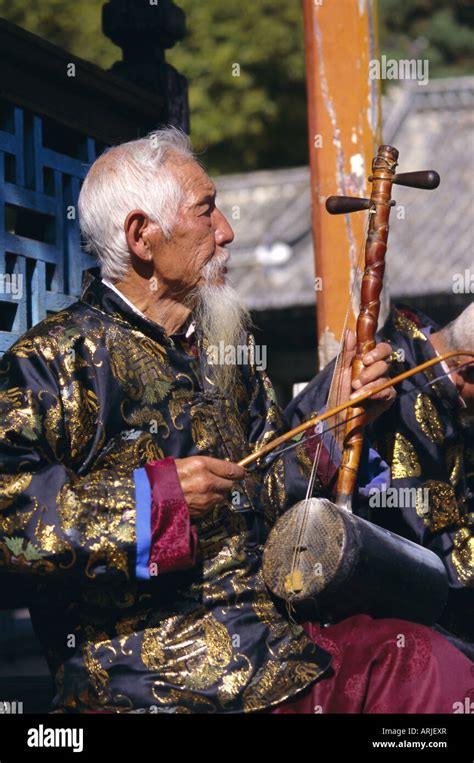 Portrait Of An Elderly Musician From The Naxi Orchestra Practising By