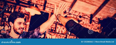 Two Young Men Giving High Five To Each Other Stock Photo Image Of