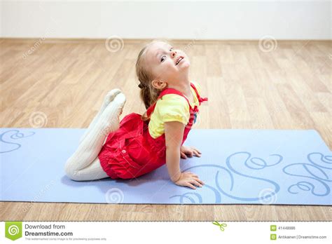 La Jolie Fille Faisant Le Yoga Pose Sur Le Tapis Dans Le Gymnase Photo