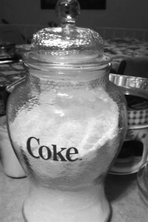 A Glass Jar Filled With Coke On Top Of A Counter