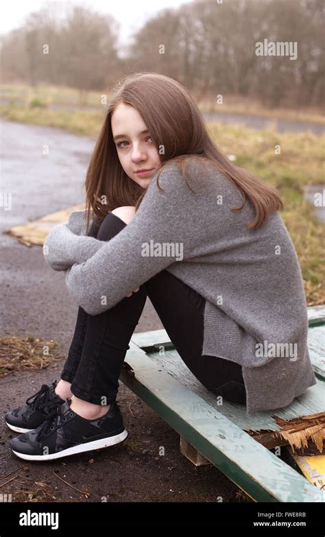Pretty Young Teenage Girl Sitting On Some Old Doors Outside A Derelict