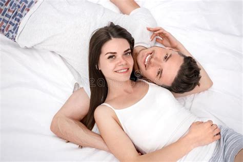 Bedtime Young Couple Lying On Bed Top View Isolated On White Hugging