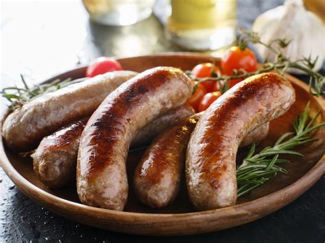 Plate Of German Bratwurst Sausages With Herbs Premium Photo