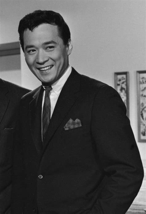 Black And White Photograph Of Two Men In Suits Smiling At The Camera With One Holding His Hand