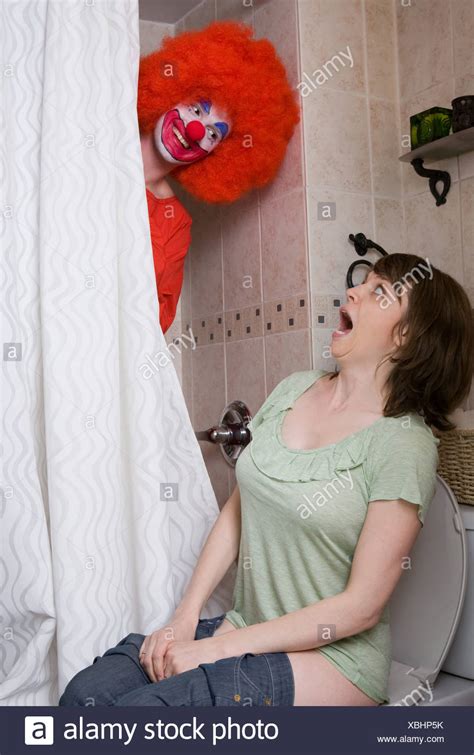 Young Woman Sitting On Toilet In Public Bathroom Portrait