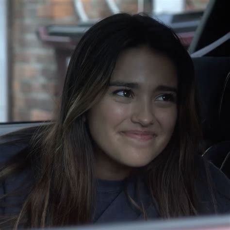 A Woman Sitting In The Passenger Seat Of A Car Smiling At The Camera While Looking Into The Distance