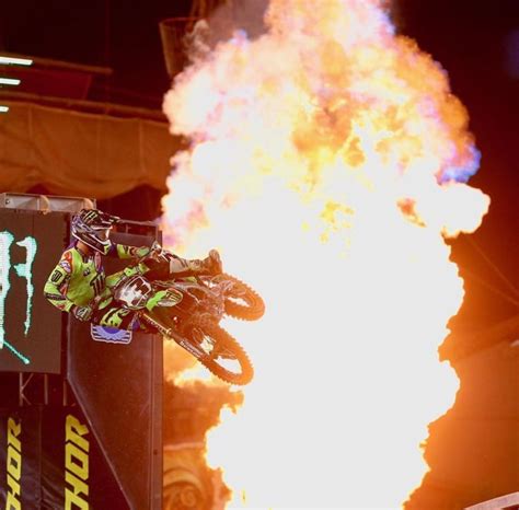 A Person On A Dirt Bike Doing Tricks In Front Of A Large Fire And Flames