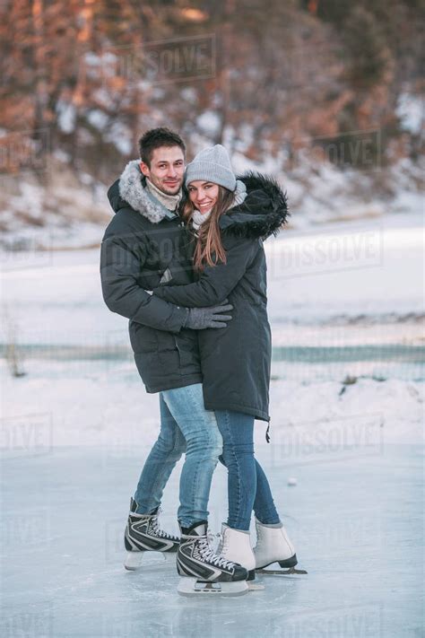 Full Length Portrait Of Happy Couple Embracing While Enjoying Ice