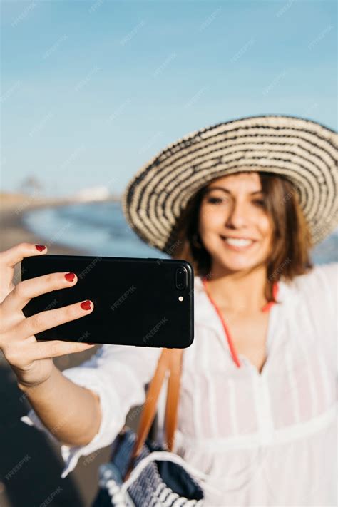 Free Photo Woman With Hat Taking Selfie At The Beach
