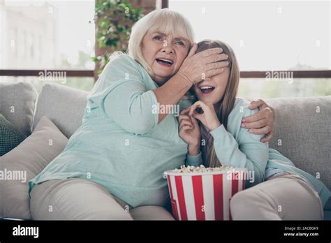 Dont Look Photo Of Two People White Haired Grandma Small Granddaughter Sit Sofa Watch Tv Scary