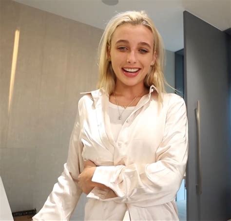 a woman standing in front of a mirror wearing a white shirt and tie around her waist