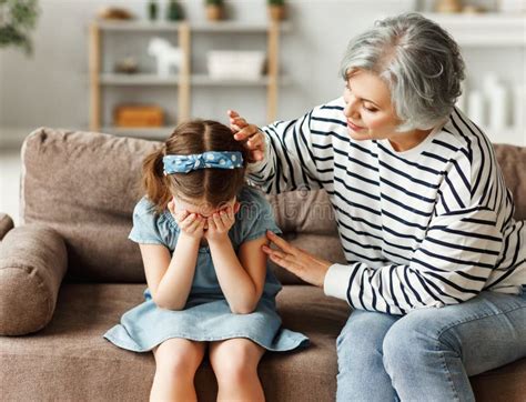 Grandmother Supporting Crying Granddaughter At Home Stock Photo Image