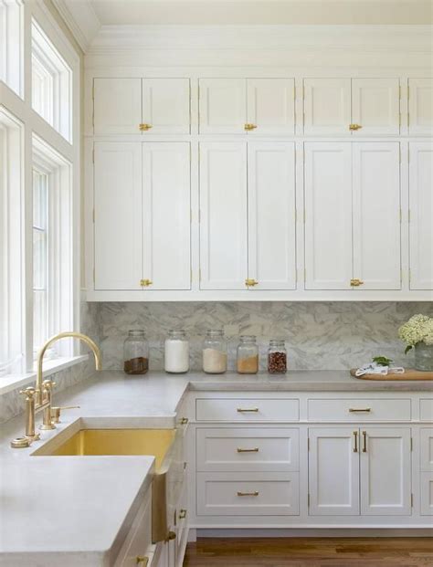 We take each project seriously. White stacked kitchen cabinets adorning vintage brass ...