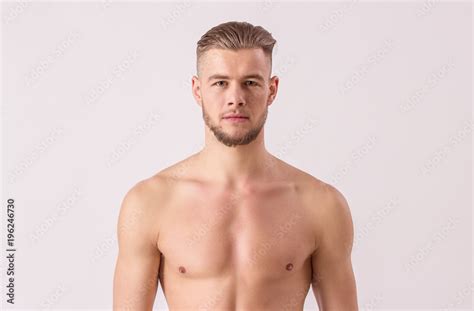 Studio Shot Of Handsome Naked Man Looking To Camera While Standing Isolated On White Background