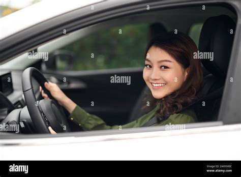 Alluring young woman driving the car and smiling Stock Photo - Alamy