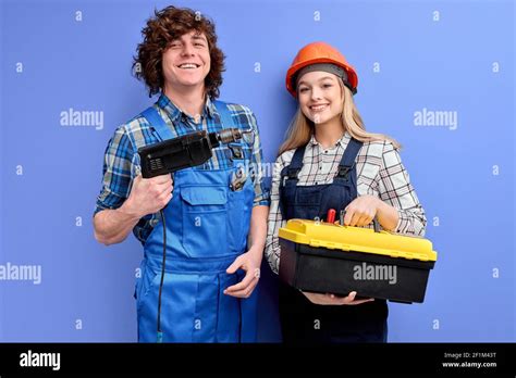 pleasant constructors with instruments tools posing isolated on blue background two builders co
