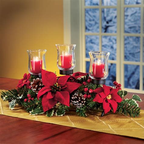 Three Candles On A Table With Poinsettis And Pine Cones In The Center