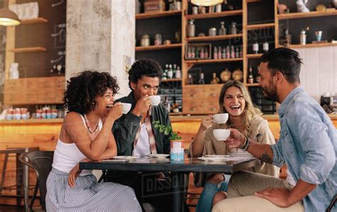 Diverse Group Of Friends Enjoying Some Coffee Together In A Restaurant And Talking Babe People