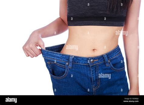 Close Up Of Woman Show Her Weight Loss And Wearing Her Old Jeans Isolated On A White Background