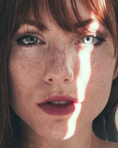 A Woman With Freckled Hair And Blue Eyes Is Posing For A Photo In The Sun