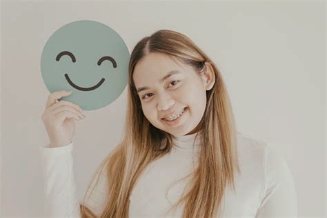 Wanita Muda Asia Yang Bahagia Memegang Wajah Emoji Senyum Konsep