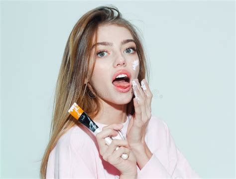 Surprised Pretty Girl Putting Facial Cream Or Mask On Face Beauty Portrait Of Female Face With