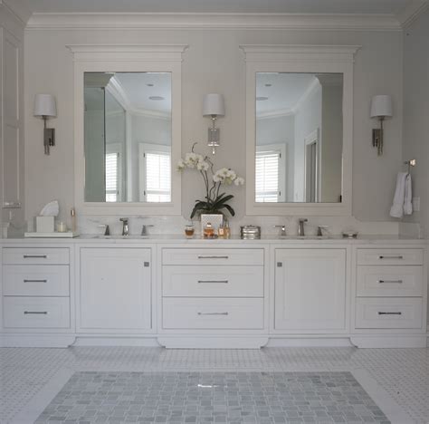 A Luxurious Double Vanity With Custom Cabinets And Shaded Sconces At