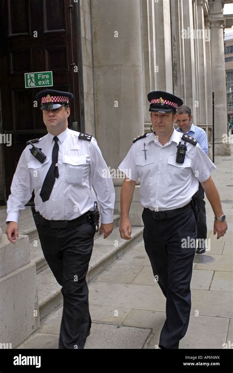 Two Male London Metropolitan Police Officers Walking The Streets Of The