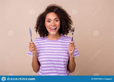 Photo Of Adorable Funky Lady Wear Violet T Shirt Showing Tongue Rising Fork Knife Isolated Beige