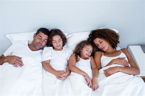 Familia Que Duerme Junto En Cama Foto De Archivo Imagen De Cama