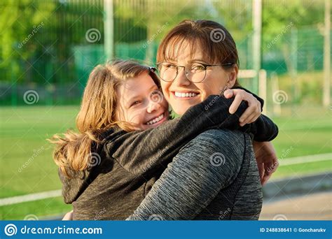 Portrait Of Happy Mom And Preteen Daughter Hugging Together Outdoor