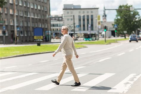 Senior Man Walking Along City Crosswalk Being Patient
