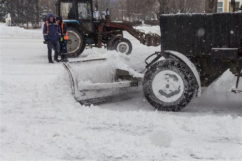 Tractors Clear The Sidewalk And The Road From Snow Snowblower