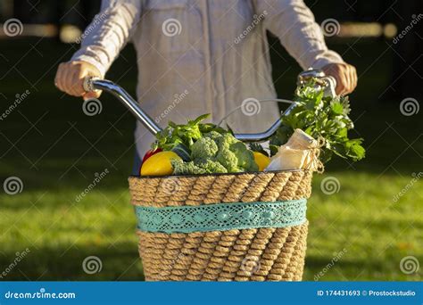 Female Riding A Bike With Fresh Vegetables From Market Stock Image